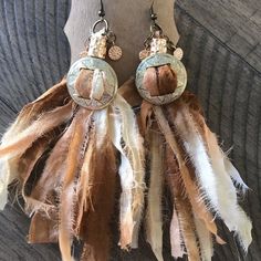 two brown and white feathers hanging from hooks