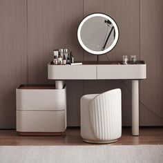 a white vanity with a round mirror and stool next to it on a wooden floor