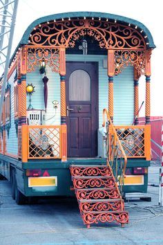 an orange and green train car with stairs leading up to it's front door