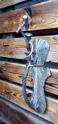 a metal horse head on the side of a wooden building with two hooks attached to it