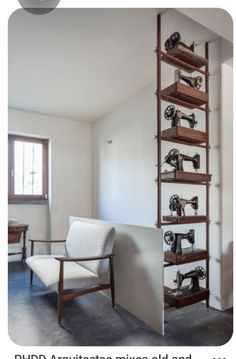 an old fashioned sewing machine is on display in the corner of a room with a chair