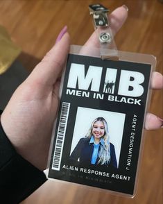 a person holding up a badge that says men in black with an image of a woman's face on it