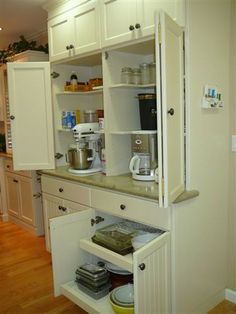 an open cabinet in the middle of a kitchen