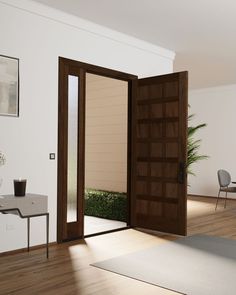 an open door in a room with wooden floors and white walls, leading to a dining area