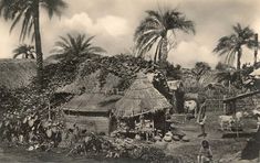 an old black and white photo of people in front of huts