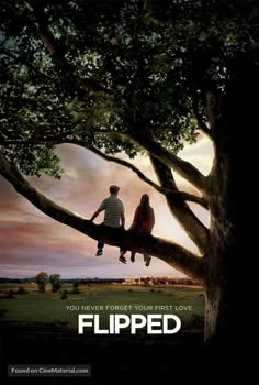 a couple sitting on top of a tree with the words flipped in front of them