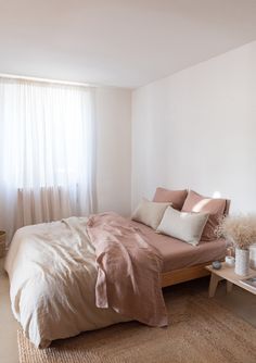 a bedroom with a bed, nightstands and window in it's center area