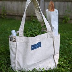 Canvas tote bag with exterior pockets, filled with food Eco-friendly Canvas Bag With Canvas Lining, Large Capacity Canvas Tote Lunch Bag, Large Capacity Canvas Lunch Bag Tote, Weekend Canvas Tote Bag With Reinforced Handles, Large Canvas Tote Lunch Bag, Casual Canvas Lunch Bag For Everyday, Cotton Tote Lunch Bag For Everyday Use, Eco-friendly Canvas Bag For Weekend, Cotton Canvas Bag With Reinforced Handles For Everyday Use