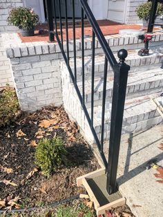 an iron stair rail on the side of a brick house