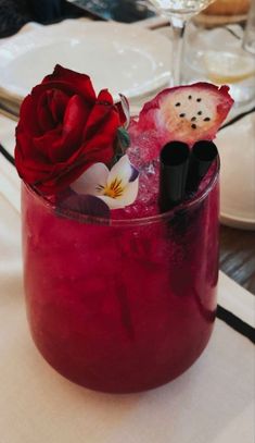 a red drink with flowers in it sitting on a table