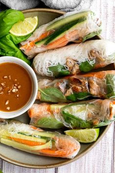 vietnamese spring rolls with dipping sauce on a plate next to lettuce and carrots