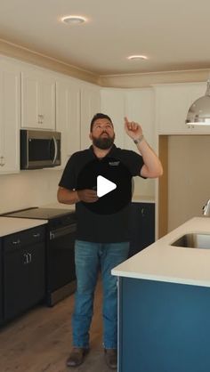 a man standing in a kitchen next to an island