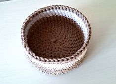 a white and brown basket sitting on top of a table