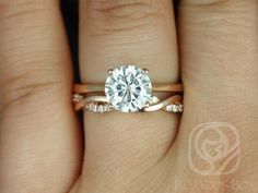 a woman's hand with a diamond ring on top of her finger and the engagement band