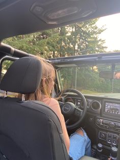 a woman sitting in the driver's seat of a vehicle