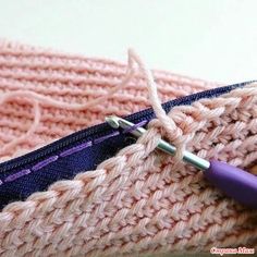 a close up of a knitted object with a crochet hook in it