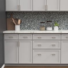 a kitchen with white cabinets and gold pulls on the doors, counter tops and drawers