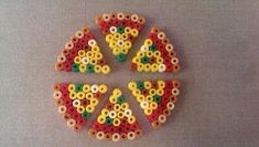 four pieces of colorful beads arranged in the shape of letters