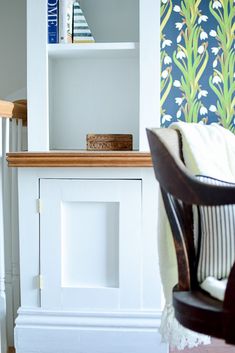 a living room with a chair and book shelf