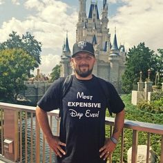 a man standing in front of a castle wearing a t - shirt that says most expensive day ever