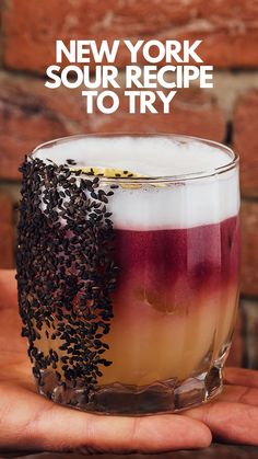 a hand holding a drink with the words new york sour recipe to try