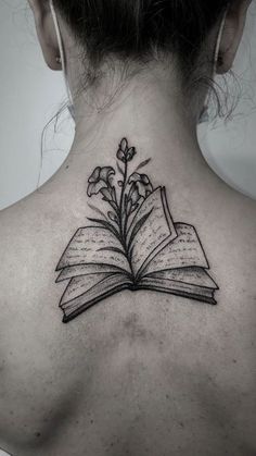 a woman with a book tattoo on her back neck and an open book in the shape of a flower