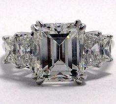 an emerald cut diamond ring with three side stones