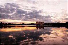 the sky is reflecting in the water at sunset with clouds reflected on the lake surface