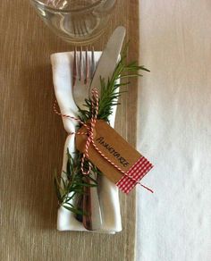 a place setting with napkins, fork and knife wrapped in twine on a table