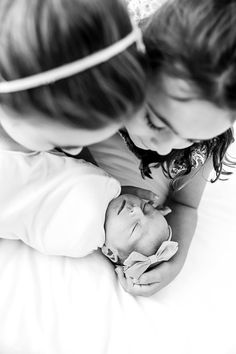 two young children laying on top of a bed next to each other with their heads together