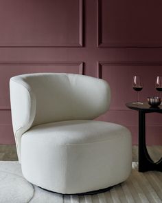 a white chair sitting next to a table with two wine glasses on top of it