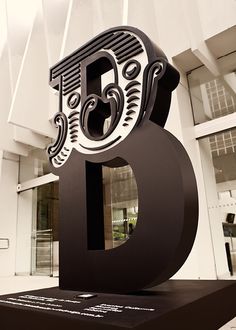 a black and white photo of the number nine in front of a building with glass windows