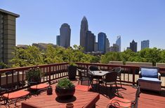 an outdoor deck with chairs and tables overlooking the city