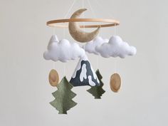 a mobile with clouds, trees and a crescent hanging from it