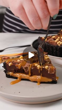 a person cutting into a piece of chocolate cheesecake with caramel drizzle