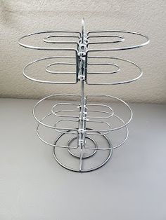 a metal rack with four circles on it and one circle is holding several items in the middle