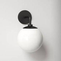 a black and white ball mounted on the side of a wall with a metal hook