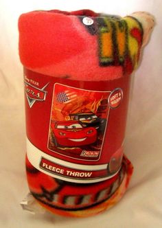 a red bucket with cars on it sitting on a white surface