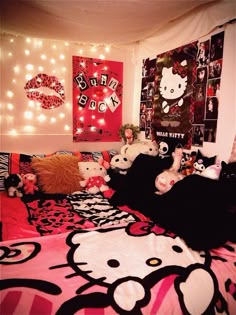 a bedroom with hello kitty bedding, lights and pictures on the wall above it