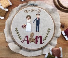 a cross stitch pattern with a couple holding hands and the word ann on it, surrounded by other sewing supplies