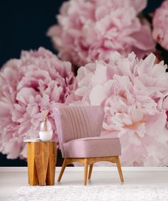 a pink chair sitting in front of a bunch of flowers