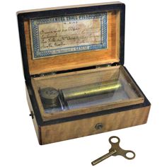 an open wooden box with a key inside