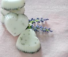 three pieces of soap sitting on top of a pink towel next to a lavender plant