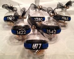 six glass christmas ornaments with numbers on them and ribbons hanging from the top one ornament