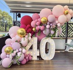 balloons and greenery decorate the number ten sign