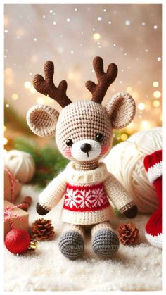 a crocheted stuffed animal with antlers on it's head sitting in front of christmas decorations