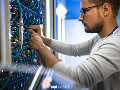 a man working on an electrical panel in a server's office or computer room