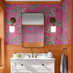 a bathroom with pink and orange wallpaper, two sinks and a large mirror on the wall