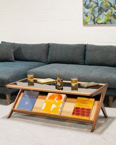 a coffee table with books on it in front of a couch