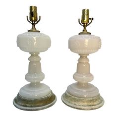 two white and gold colored candlesticks sitting side by side on top of each other